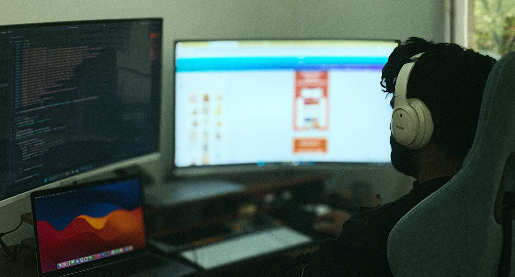 Profissional de software trabalhando com múltiplos monitores em ambiente moderno de sistemas