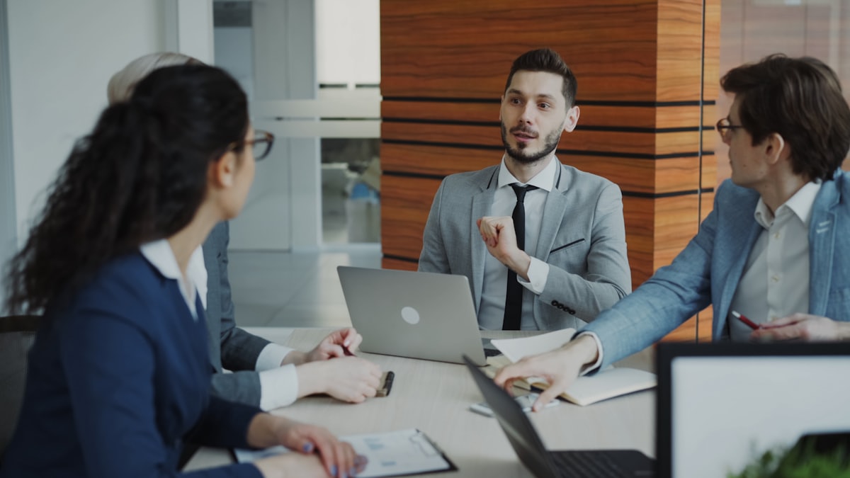 Profissionais analisando informações e discutindo decisões em ambiente empresarial